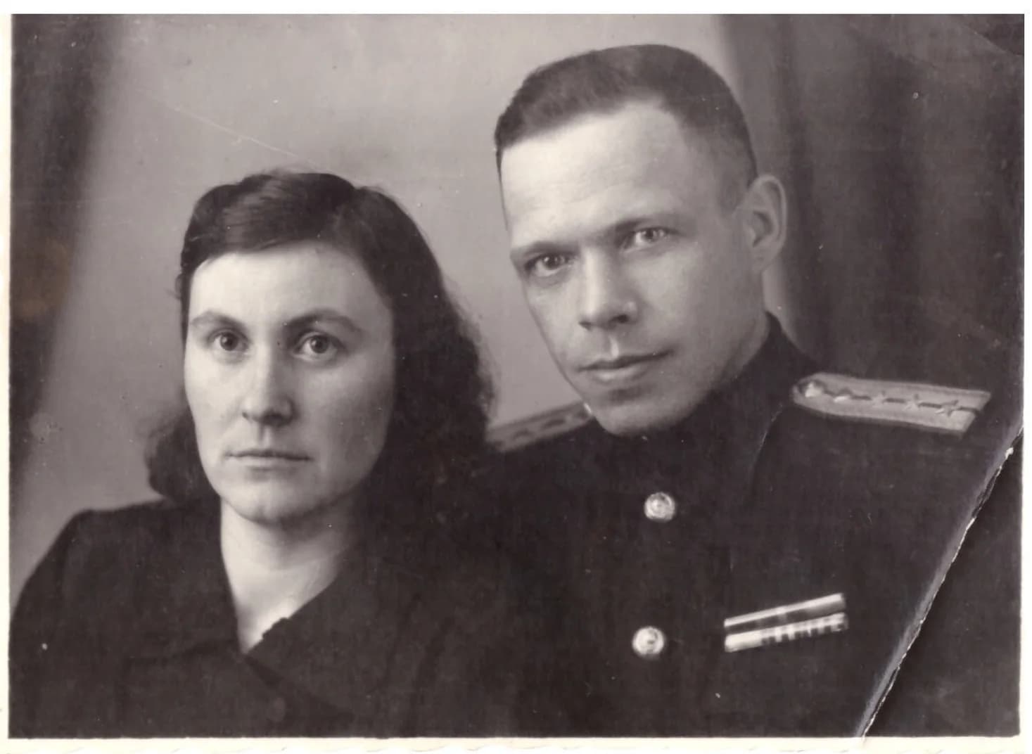 Старая фотография женщины и мужчины в военной форме с погонами: залом у правого края, потёртости и мягкая резкость