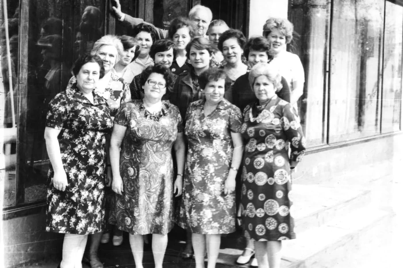 Чёрно-белая групповая фотография женщин у стеклянной витрины здания, снимок советского времени