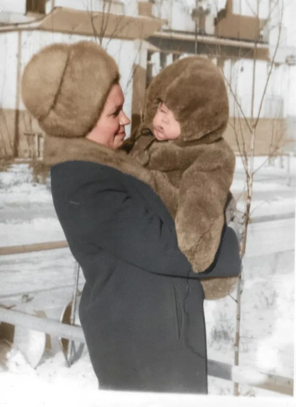 Та же зимняя фотография в цвете: коричневый мех детского комбинезона, тёмное пальто женщины, снег остался белым
