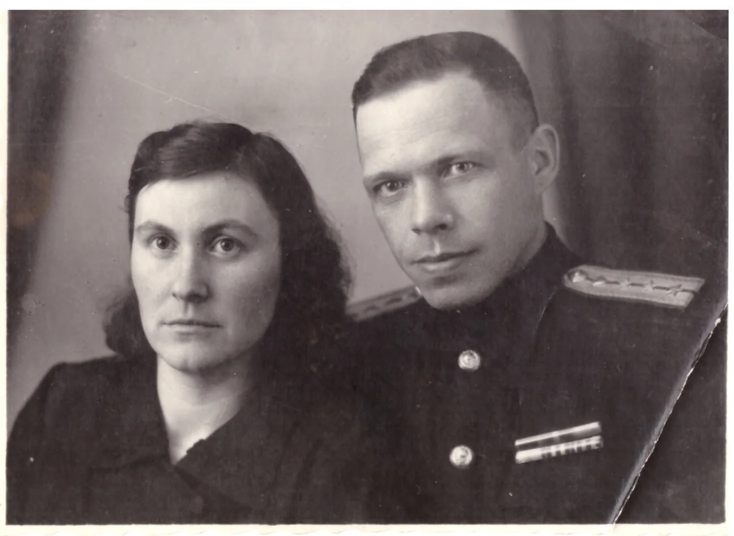 Старая фотография женщины и мужчины в военной форме с погонами: залом у правого края, потёртости и мягкая резкость